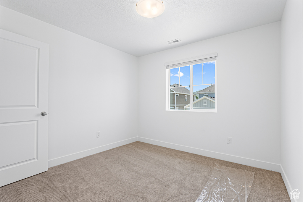Unfurnished room featuring carpet and baseboards