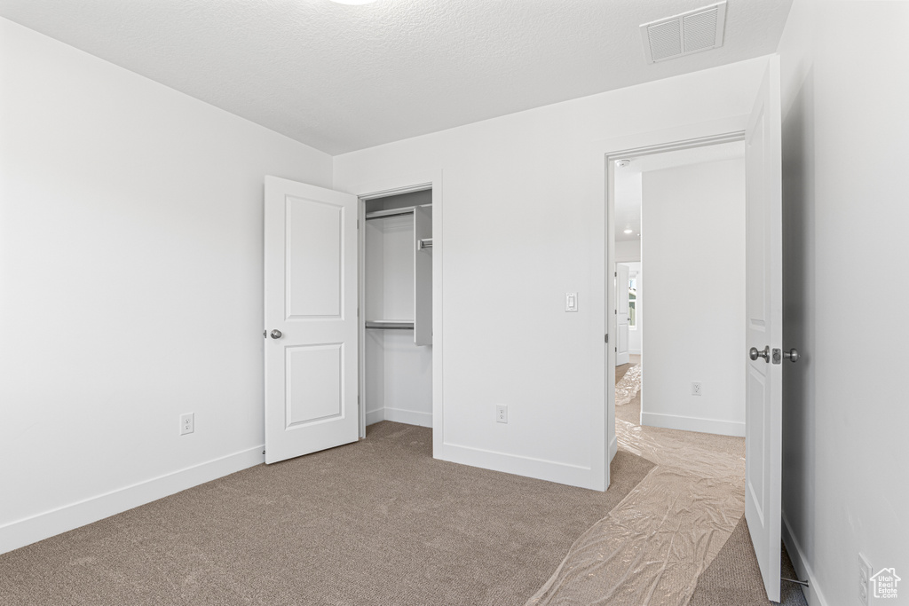 Unfurnished bedroom with carpet flooring and a closet