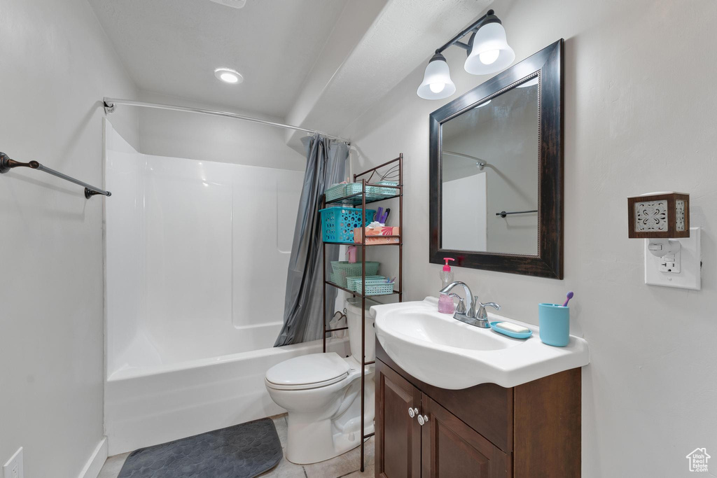 Full bathroom with toilet, shower / tub combo with curtain, vanity, and tile patterned flooring