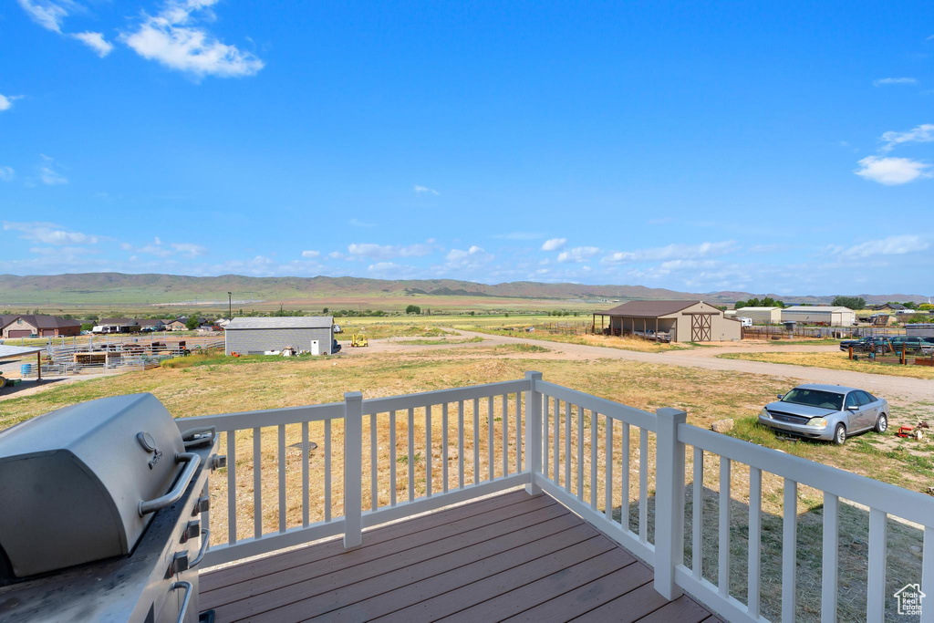 Deck with a grill, a mountain view, and a shed