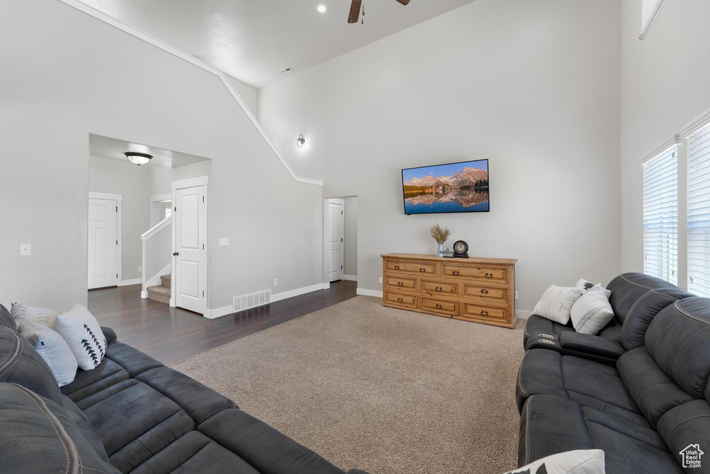 Living room featuring ceiling fan, high vaulted ceiling, and dark wood-type flooring