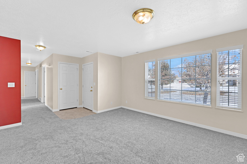 Carpeted spare room featuring a textured ceiling