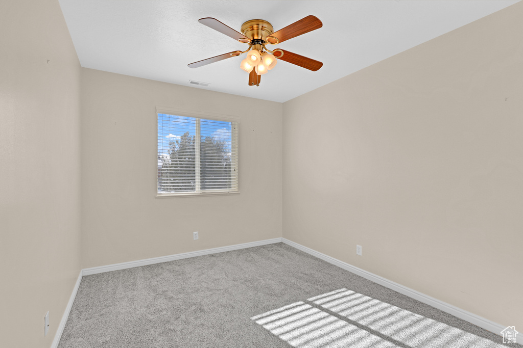 Carpeted empty room with ceiling fan