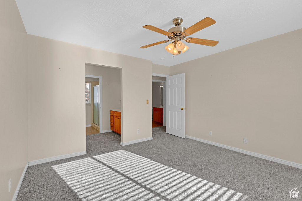 Unfurnished bedroom featuring ceiling fan, light colored carpet, and connected bathroom