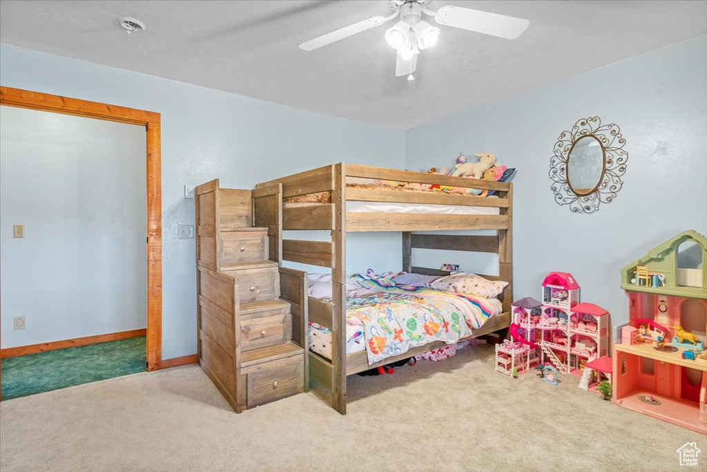 Carpeted bedroom featuring ceiling fan