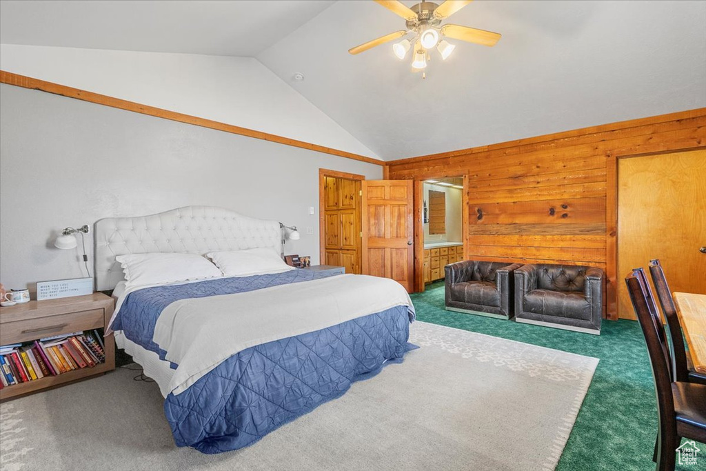 Carpeted bedroom featuring wooden walls, ceiling fan, and lofted ceiling