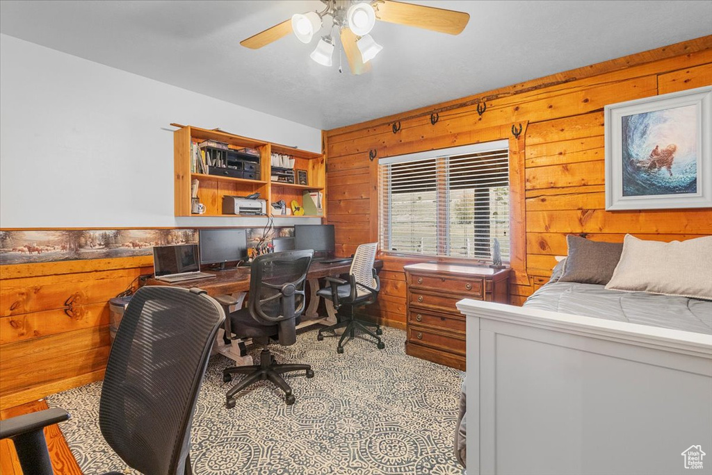 Bedroom with ceiling fan and wood walls