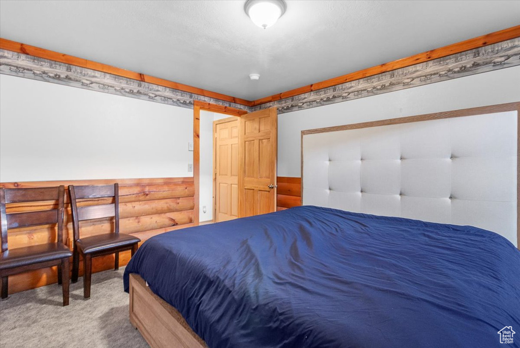 Carpeted bedroom with wood walls