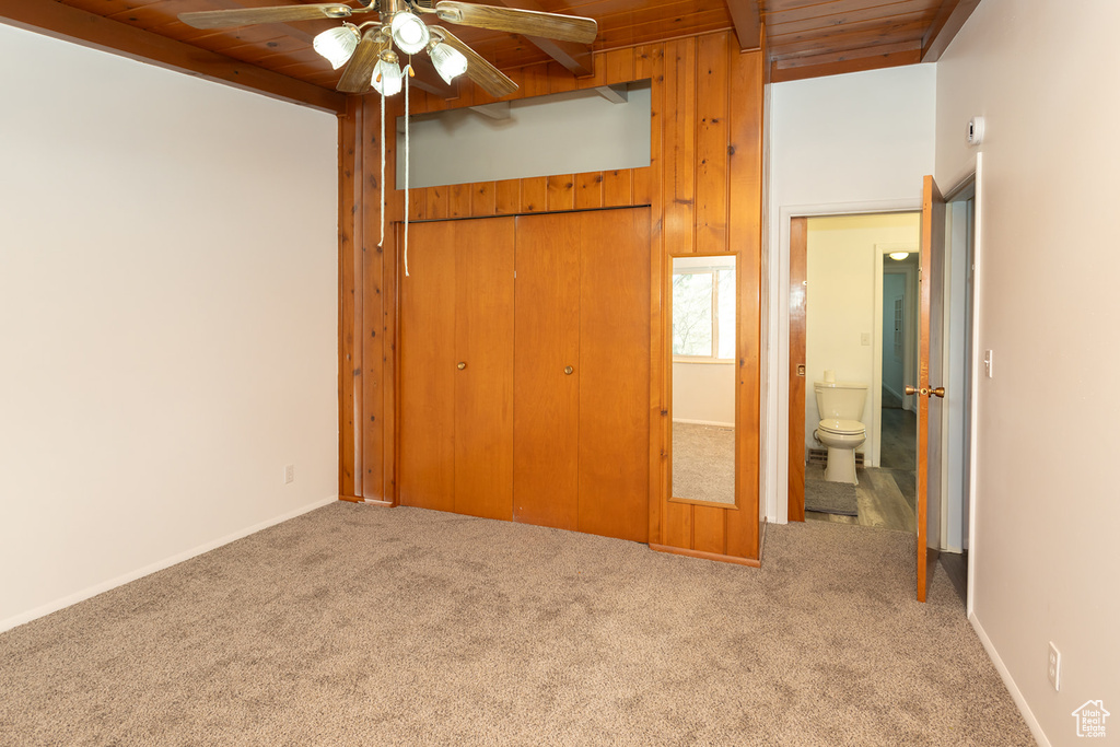Unfurnished bedroom featuring carpet flooring, ceiling fan, a closet, and wooden ceiling
