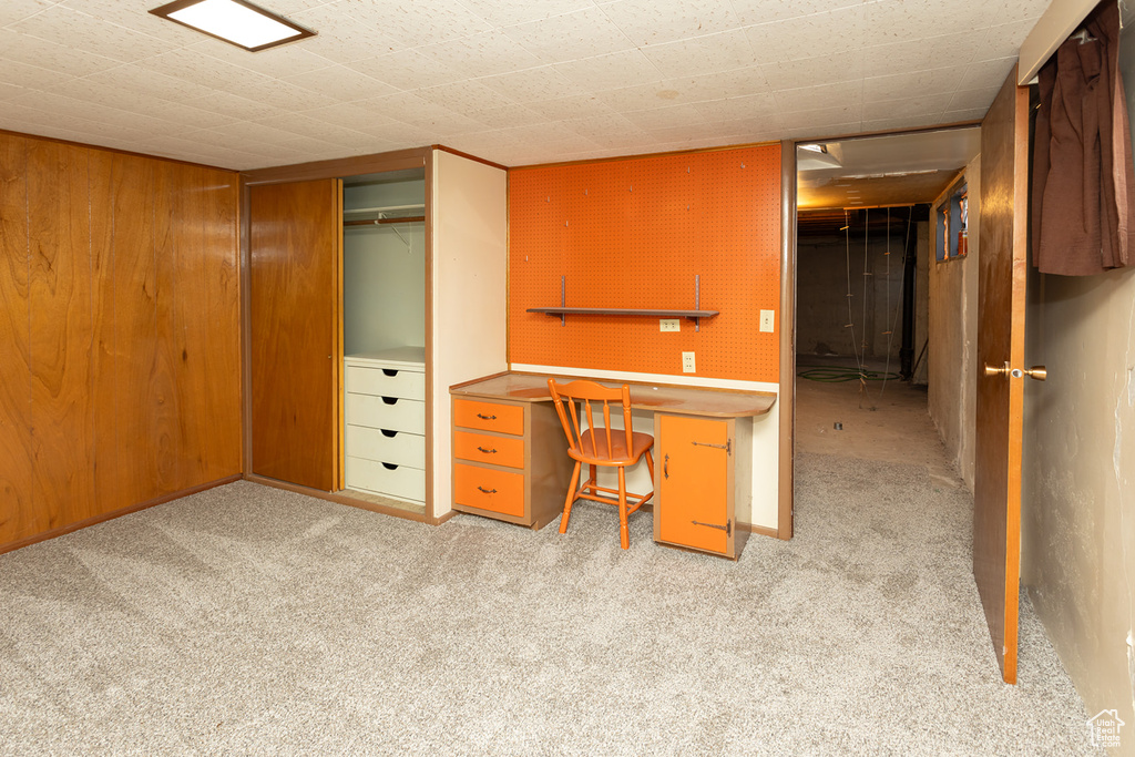 Unfurnished office featuring light carpet and wood walls
