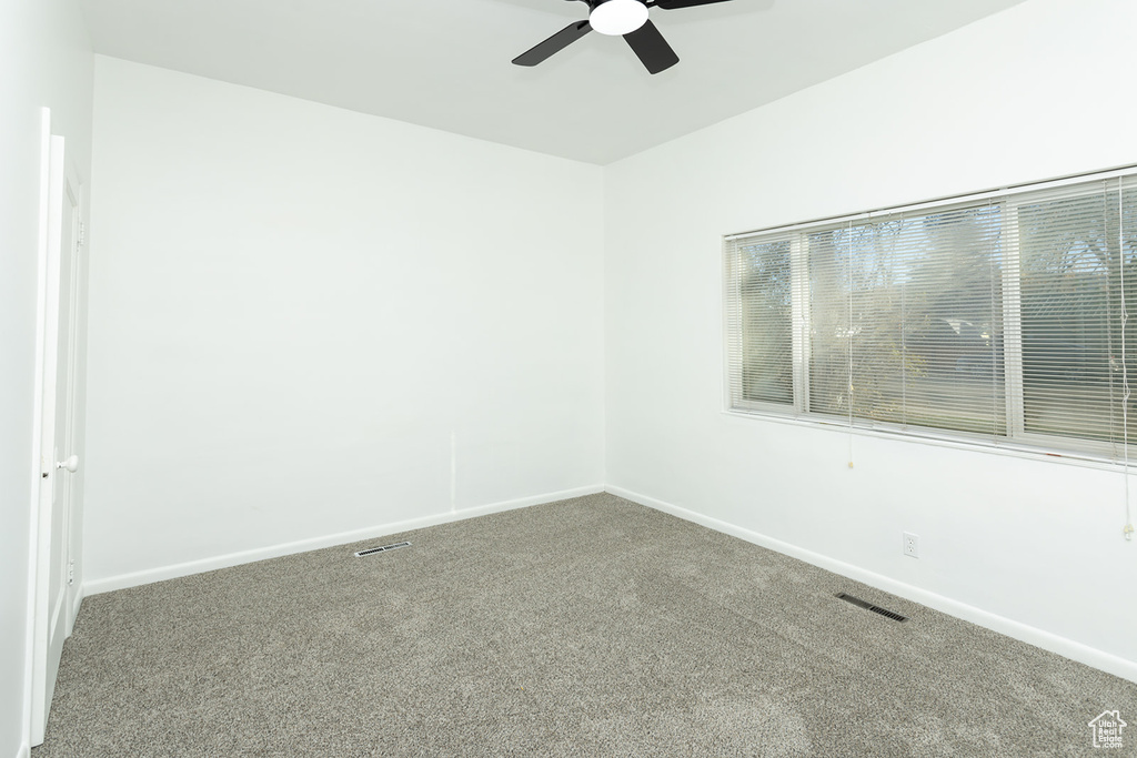 Carpeted spare room with ceiling fan