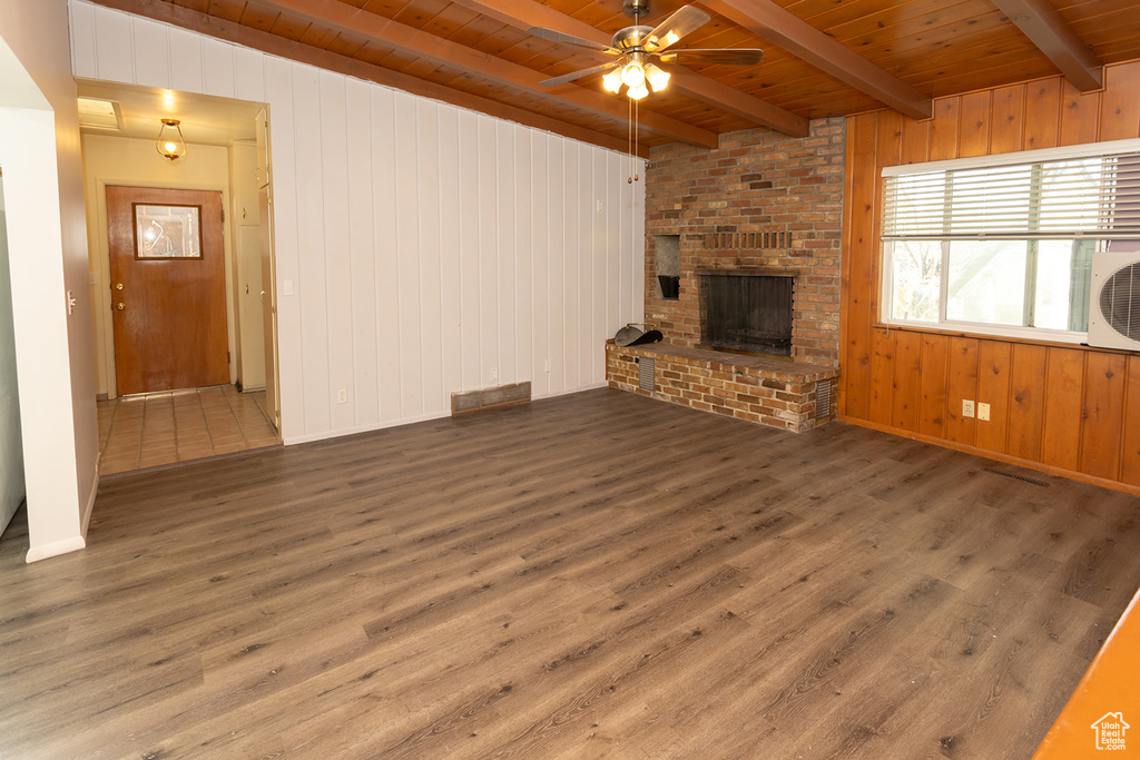 Unfurnished living room featuring beam ceiling, dark hardwood / wood-style floors, and wooden ceiling