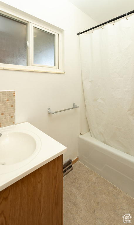 Bathroom featuring vanity, tile patterned floors, and shower / bath combo with shower curtain