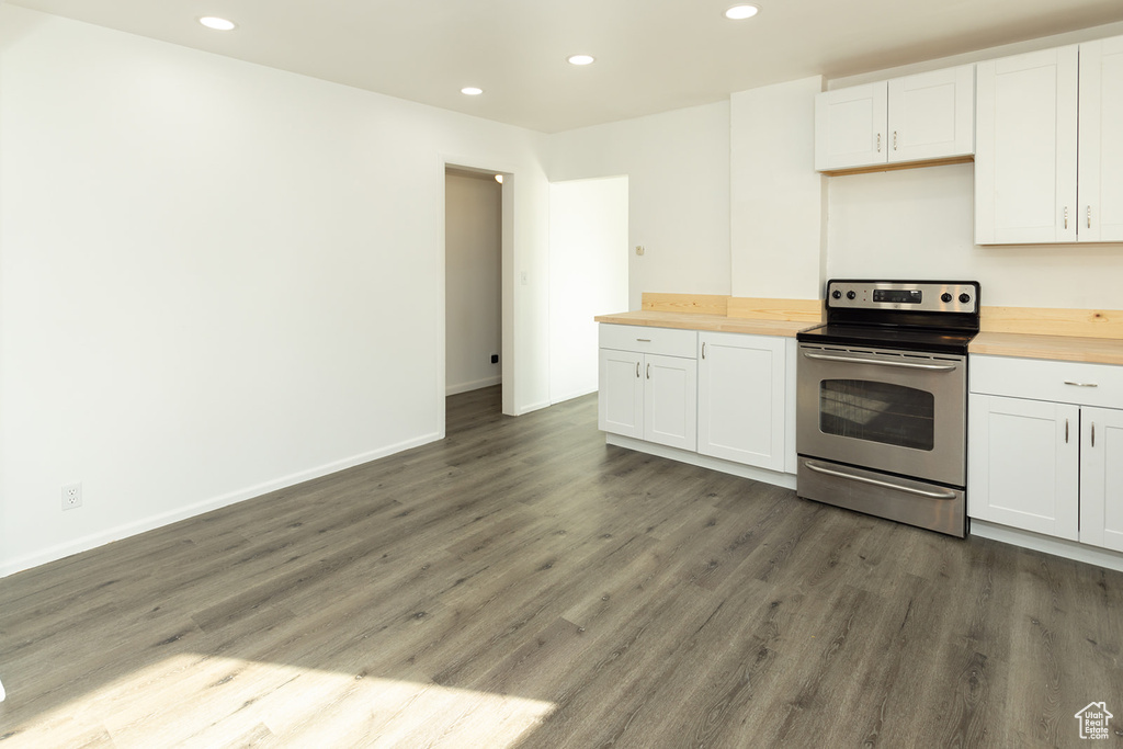 Kitchen featuring white cabinets, stainless steel range with electric cooktop, and wooden counters