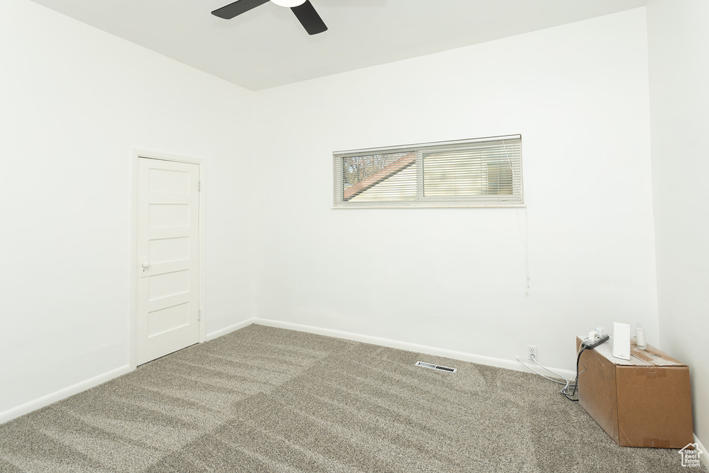 Carpeted empty room with ceiling fan