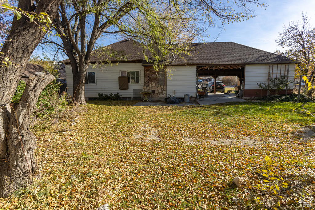 Rear view of house with a lawn and a carport