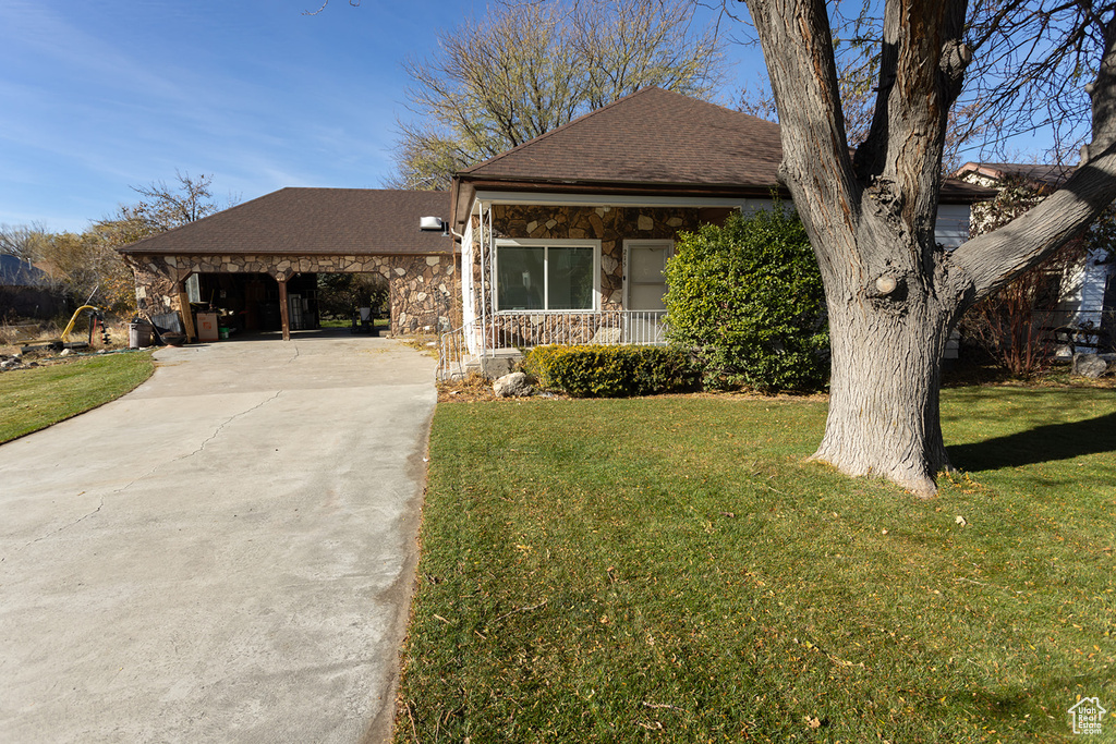 View of front of home with a carport and a front lawn