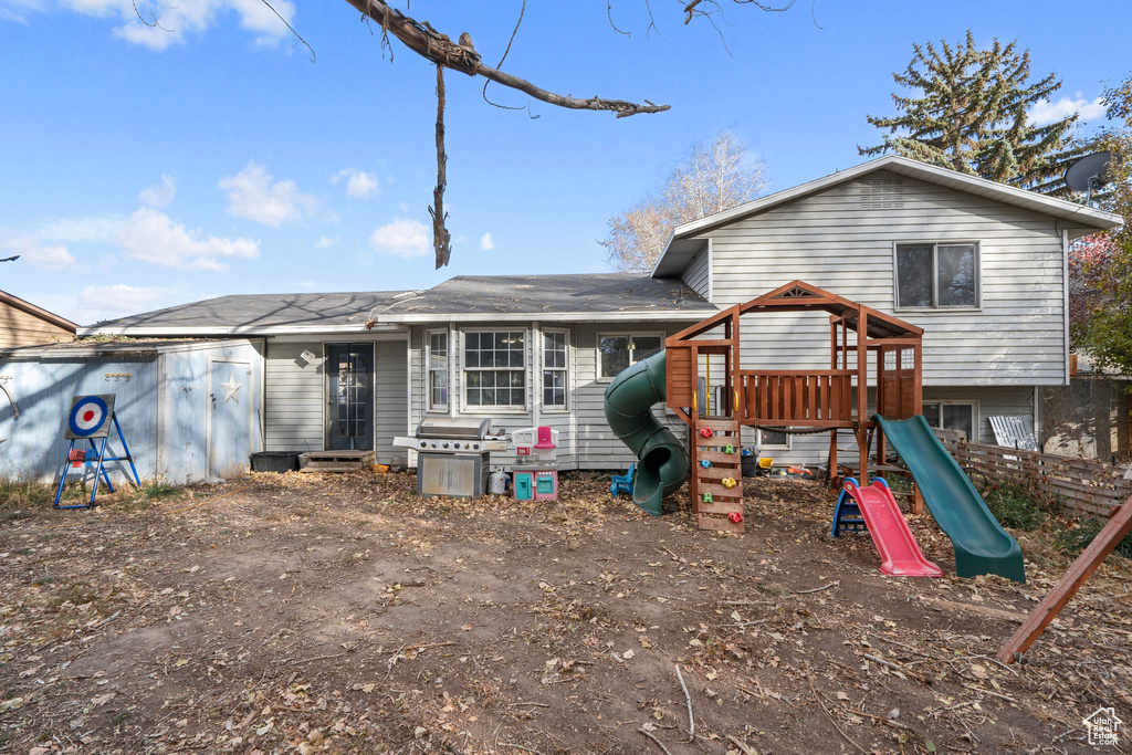 Rear view of property with a playground