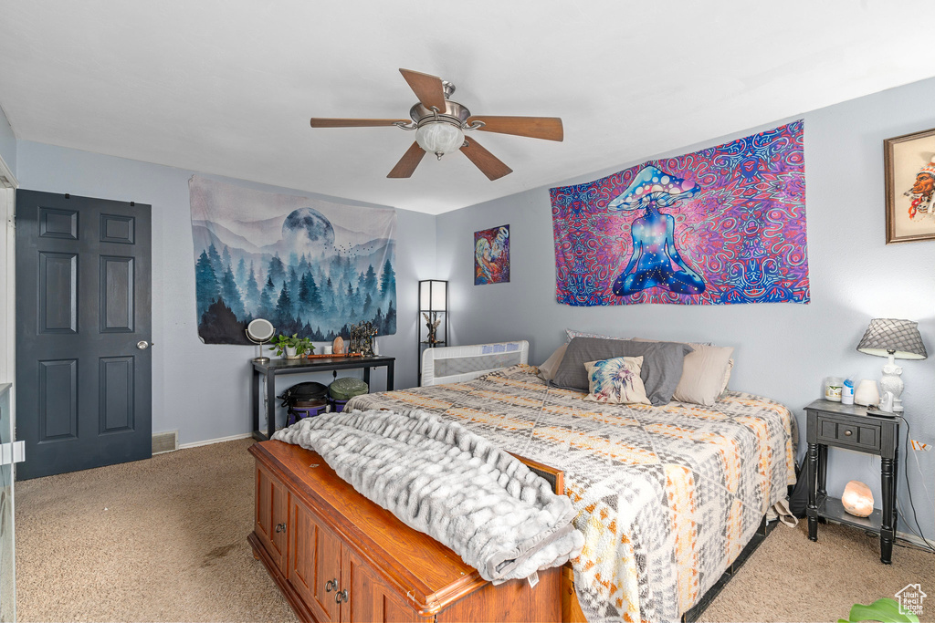 Bedroom with ceiling fan and light carpet