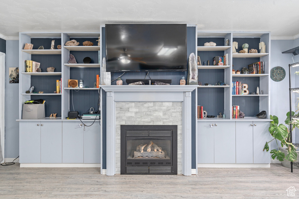 Living room with light wood-type flooring and ornamental molding