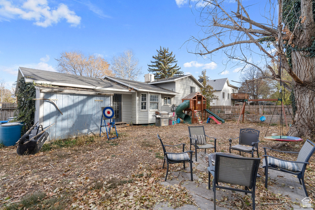 Rear view of property featuring a playground