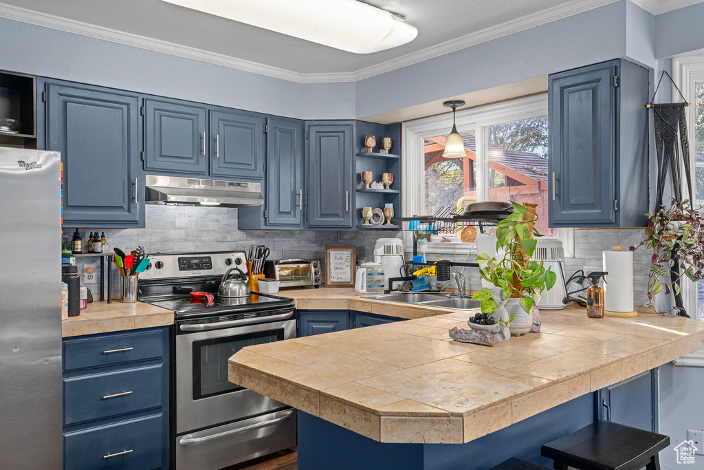 Kitchen featuring pendant lighting, kitchen peninsula, blue cabinetry, and appliances with stainless steel finishes