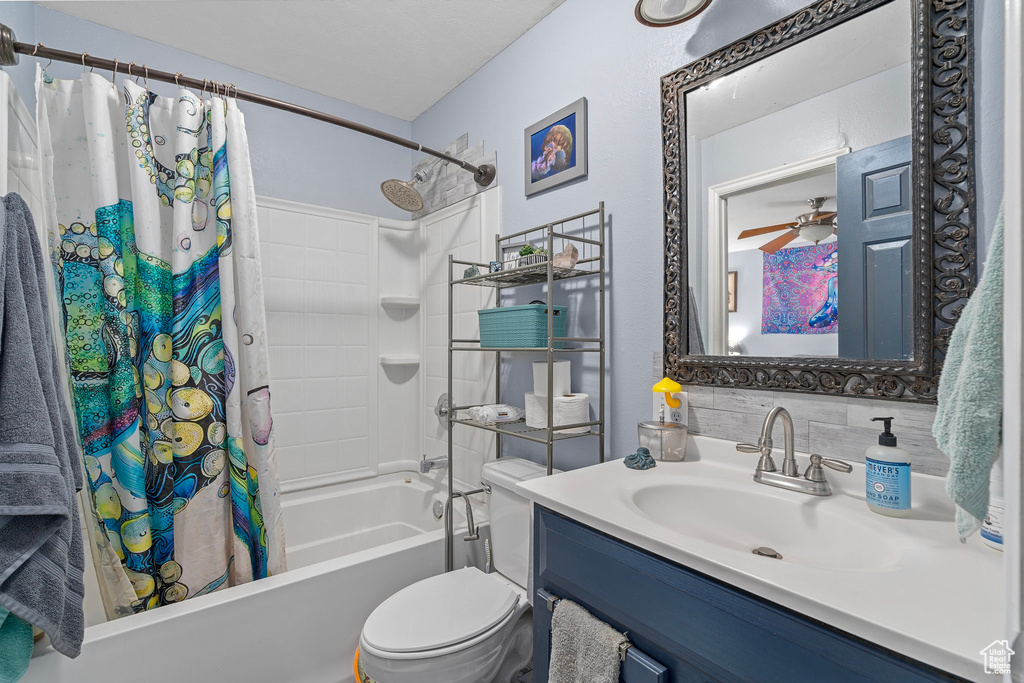 Full bathroom featuring shower / tub combo, backsplash, vanity, ceiling fan, and toilet