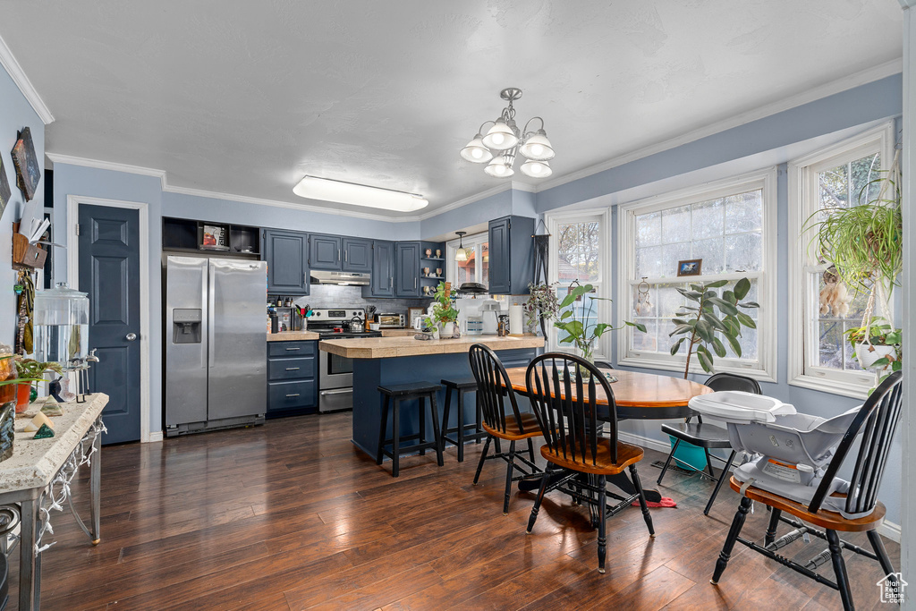 Dining room featuring dark hardwood / wood-style flooring, crown molding, and a chandelier