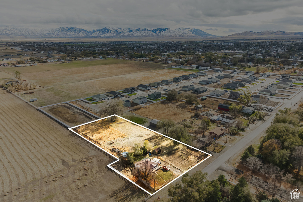 Aerial view of residential area with property parcel outlined and mountains