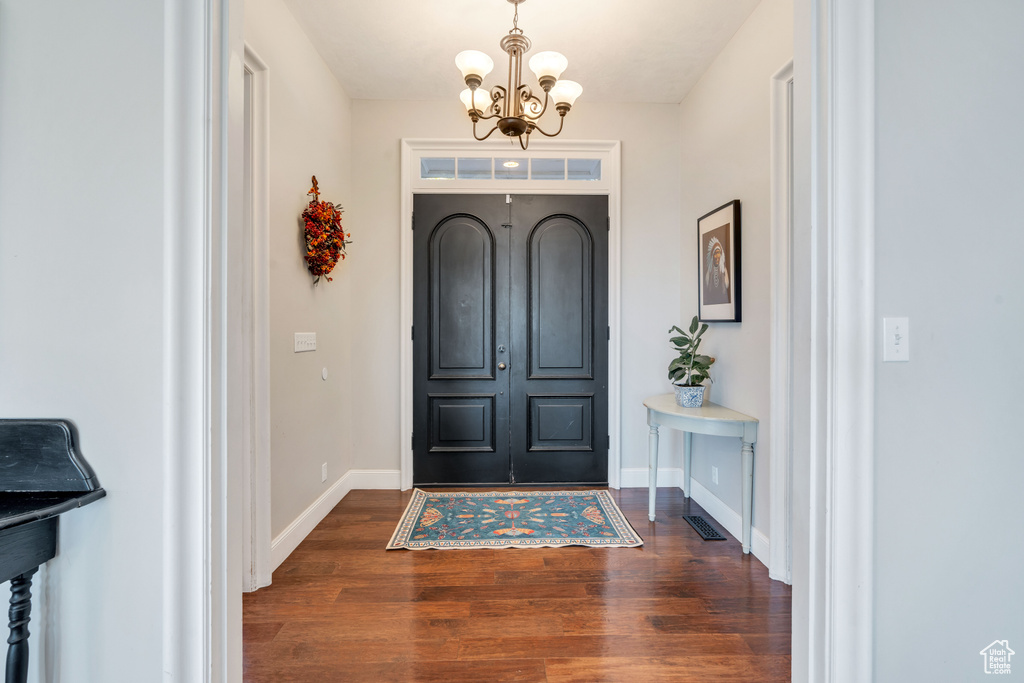 Entryway featuring a chandelier and dark wood-type flooring