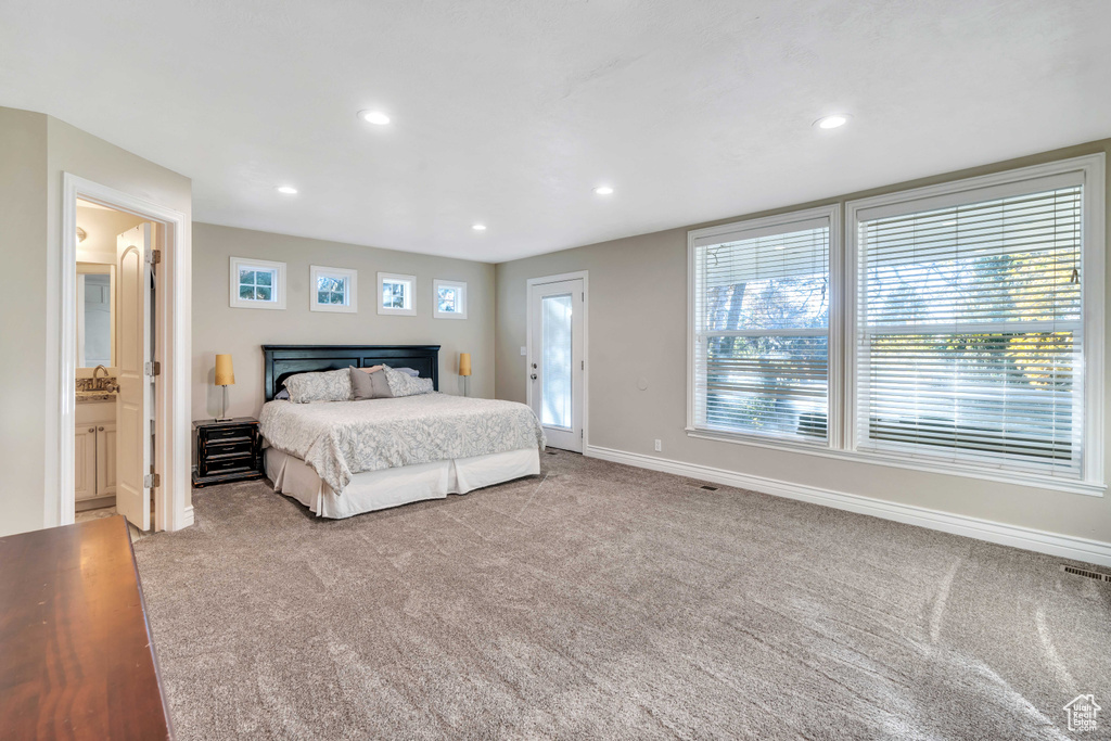 Bedroom with light carpet and connected bathroom