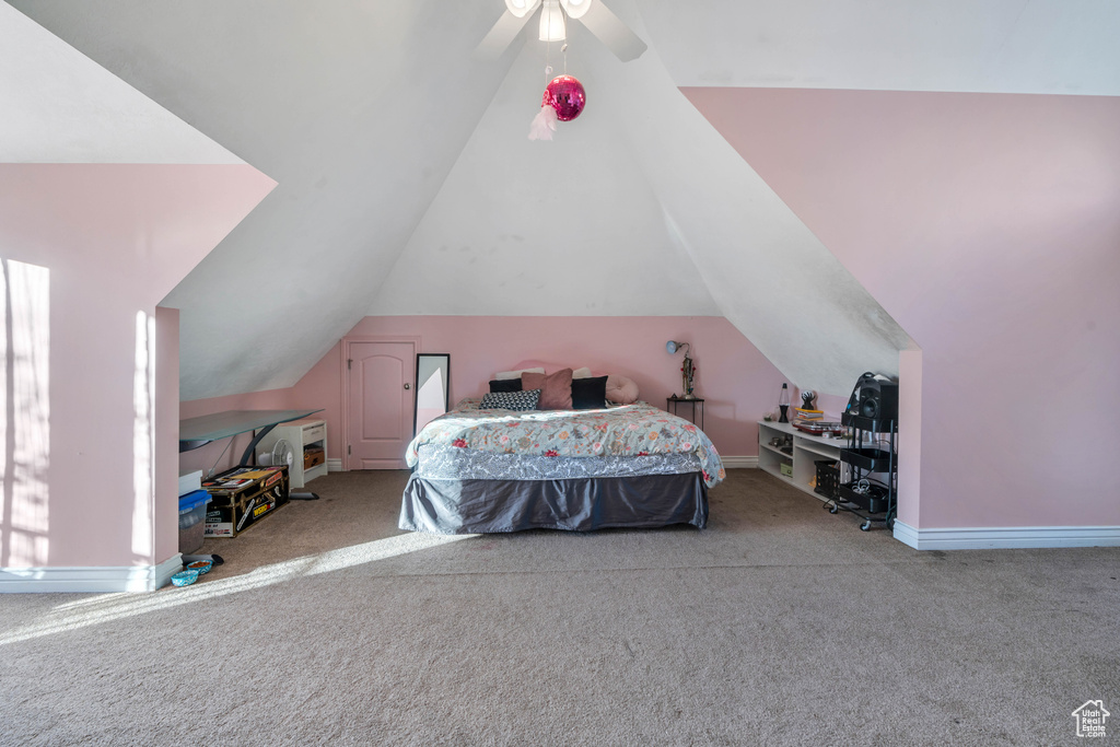 Carpeted bedroom with vaulted ceiling and ceiling fan