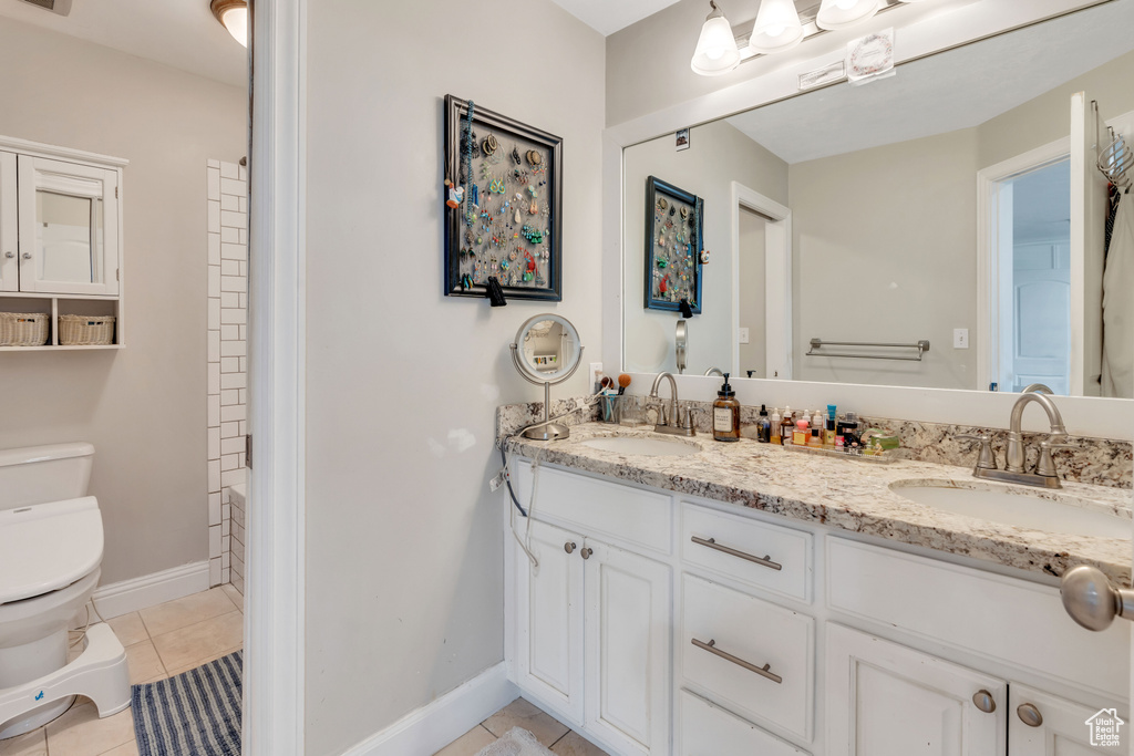 Bathroom with tile patterned floors, vanity, and toilet