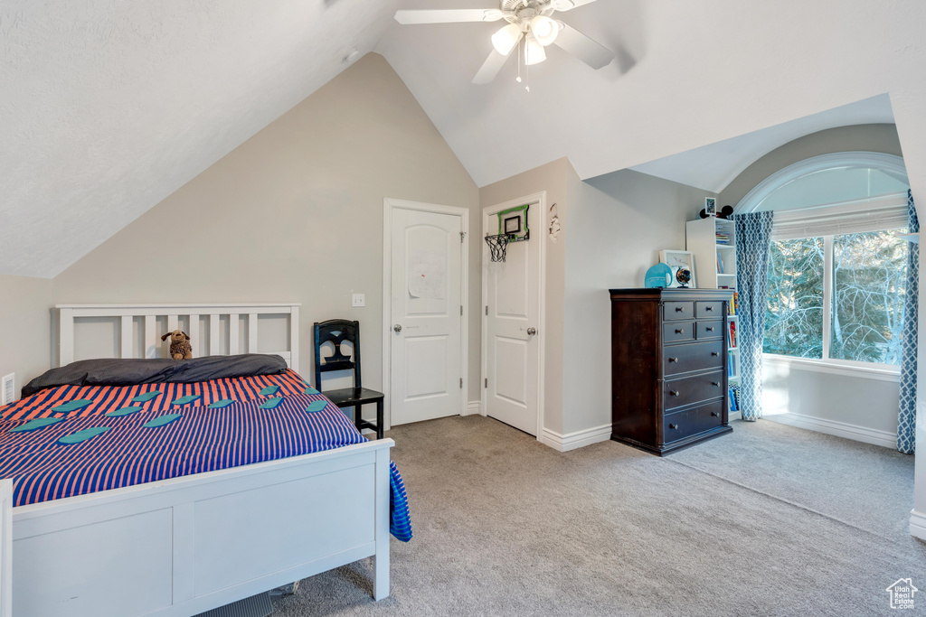 Bedroom featuring light carpet, vaulted ceiling, and ceiling fan