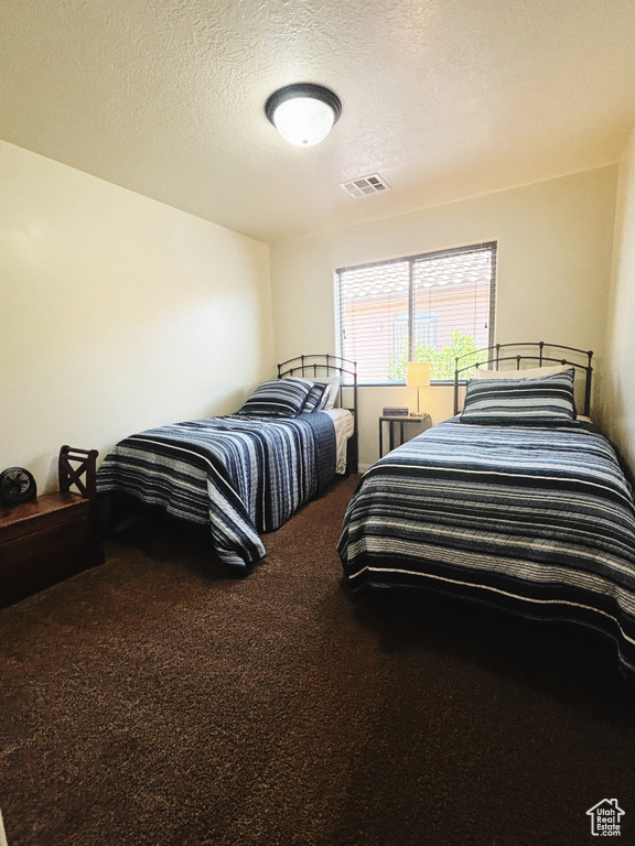 Carpeted bedroom with a textured ceiling