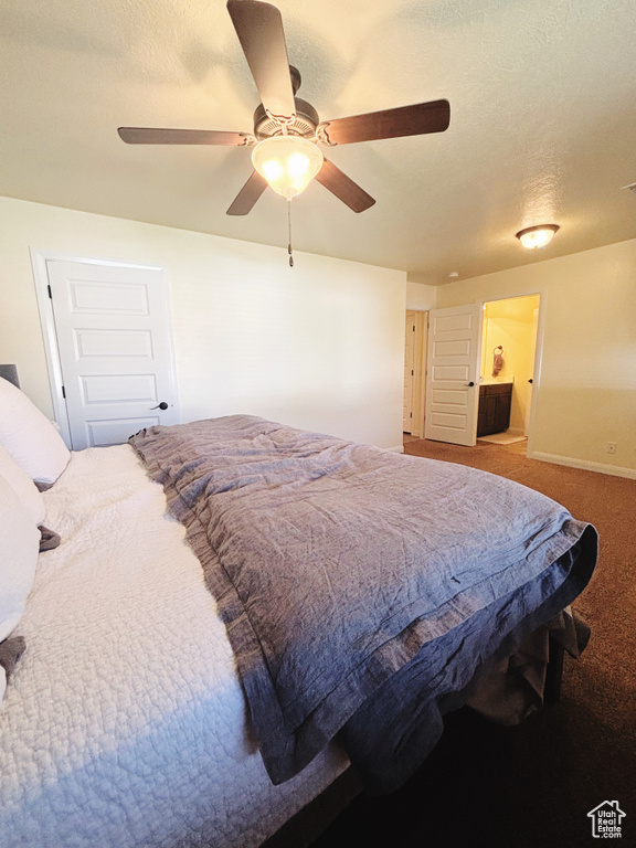 Carpeted bedroom featuring a textured ceiling and ceiling fan