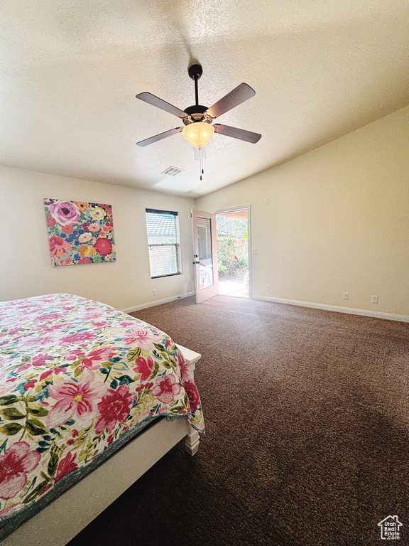 Bedroom with a textured ceiling, carpet floors, and ceiling fan