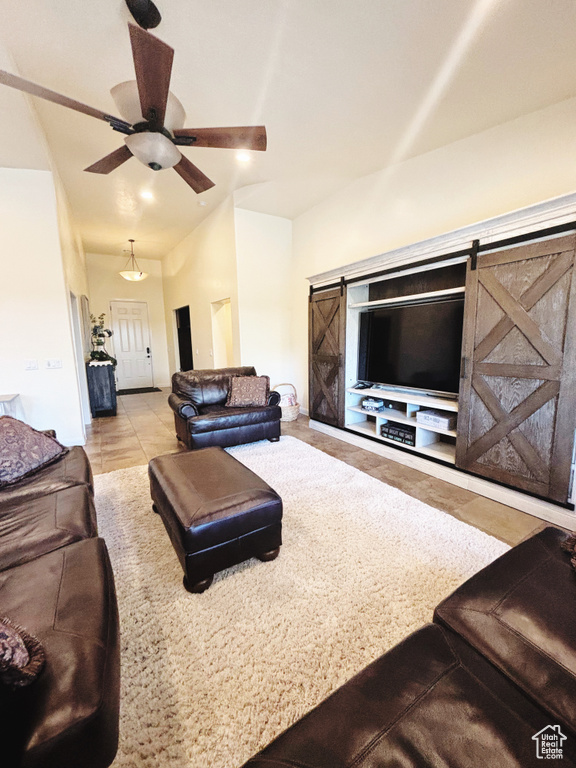 Tiled living room with a barn door and ceiling fan