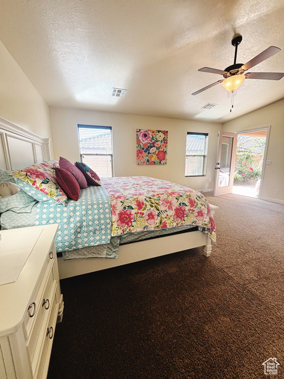 Bedroom with multiple windows, ceiling fan, carpet, and a textured ceiling