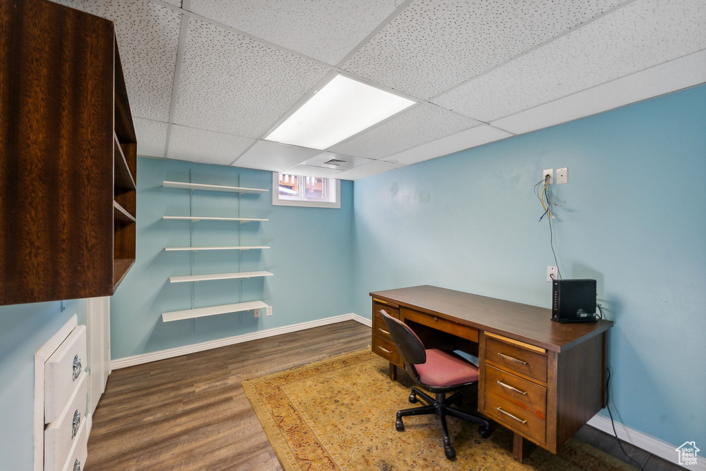 Office with a paneled ceiling and dark hardwood / wood-style floors