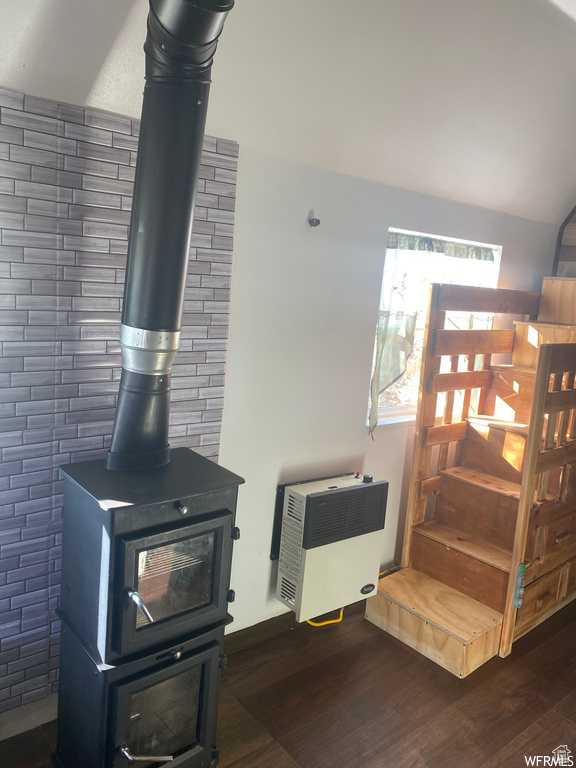 Interior details featuring hardwood / wood-style floors, heating unit, and a wood stove