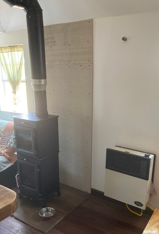 Details featuring hardwood / wood-style flooring, a wood stove, and heating unit