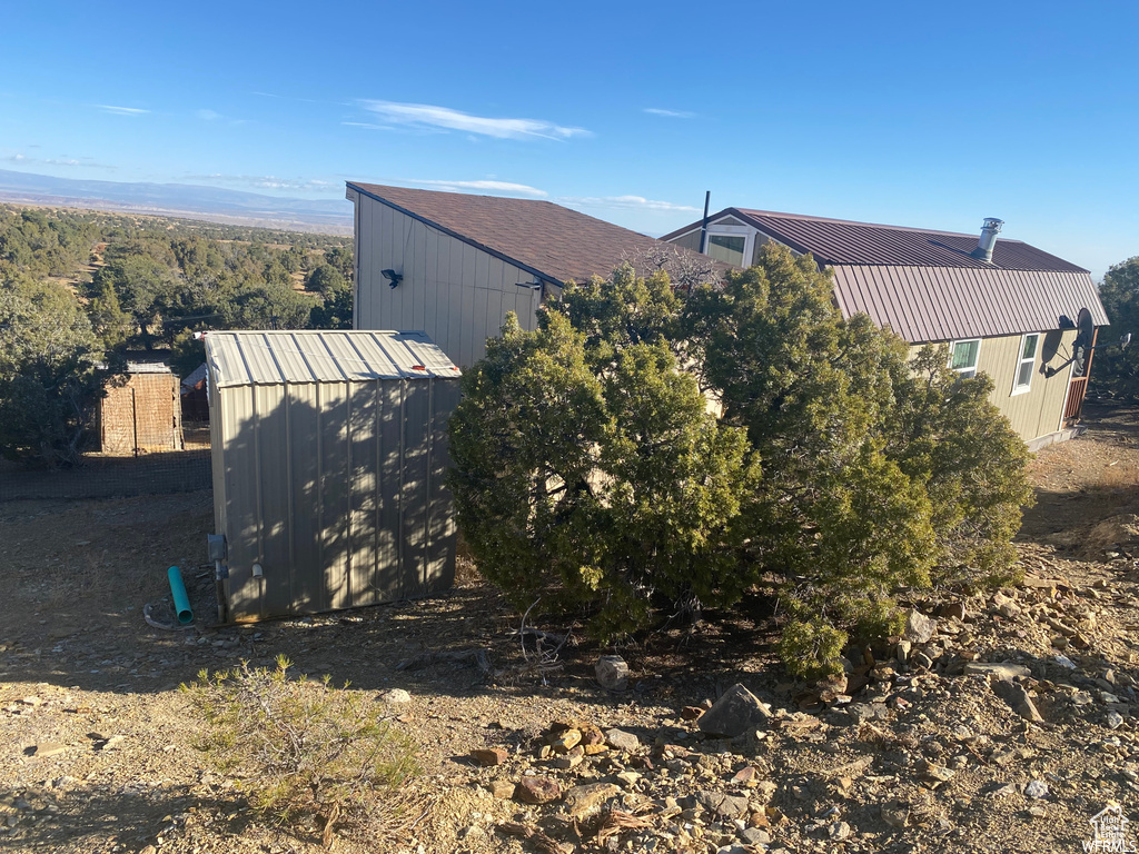 View of side of home featuring a storage shed