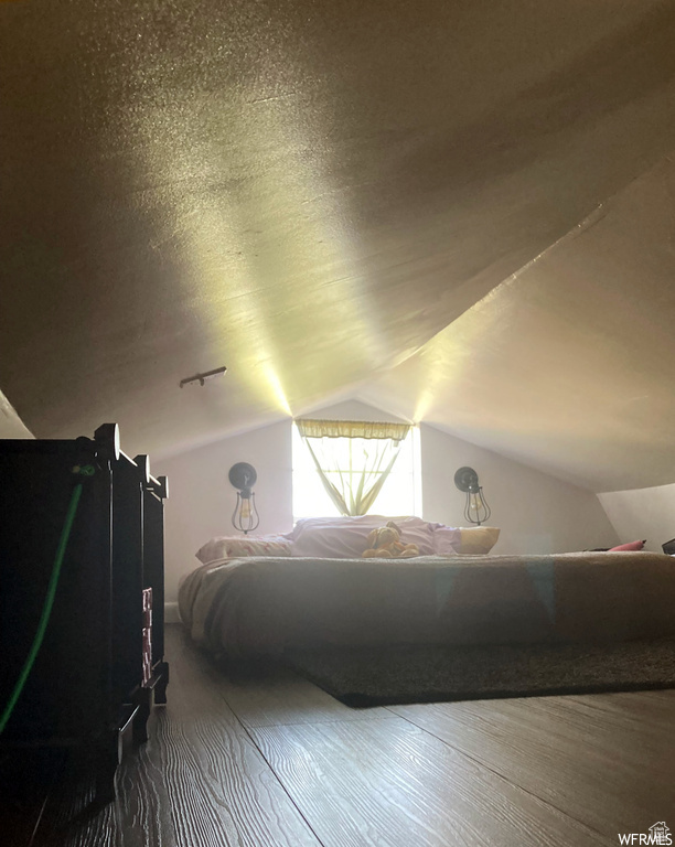 Bedroom featuring hardwood / wood-style floors and lofted ceiling