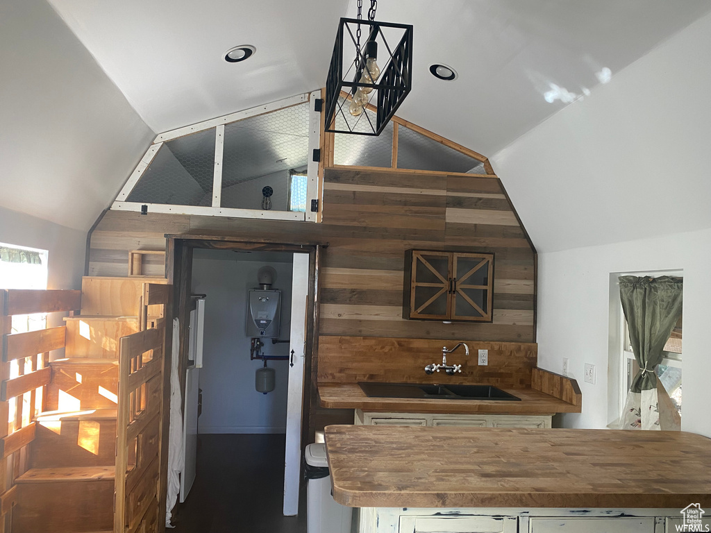 Kitchen featuring lofted ceiling, sink, and wooden counters