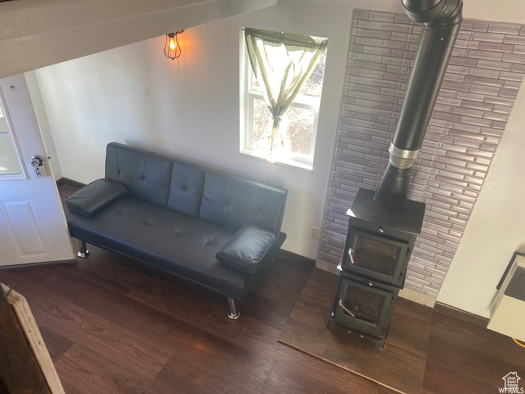 Living area with dark hardwood / wood-style floors and a wood stove