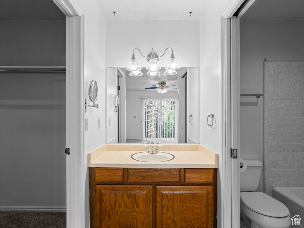 Full bathroom with vanity, toilet, ceiling fan, and  shower combination