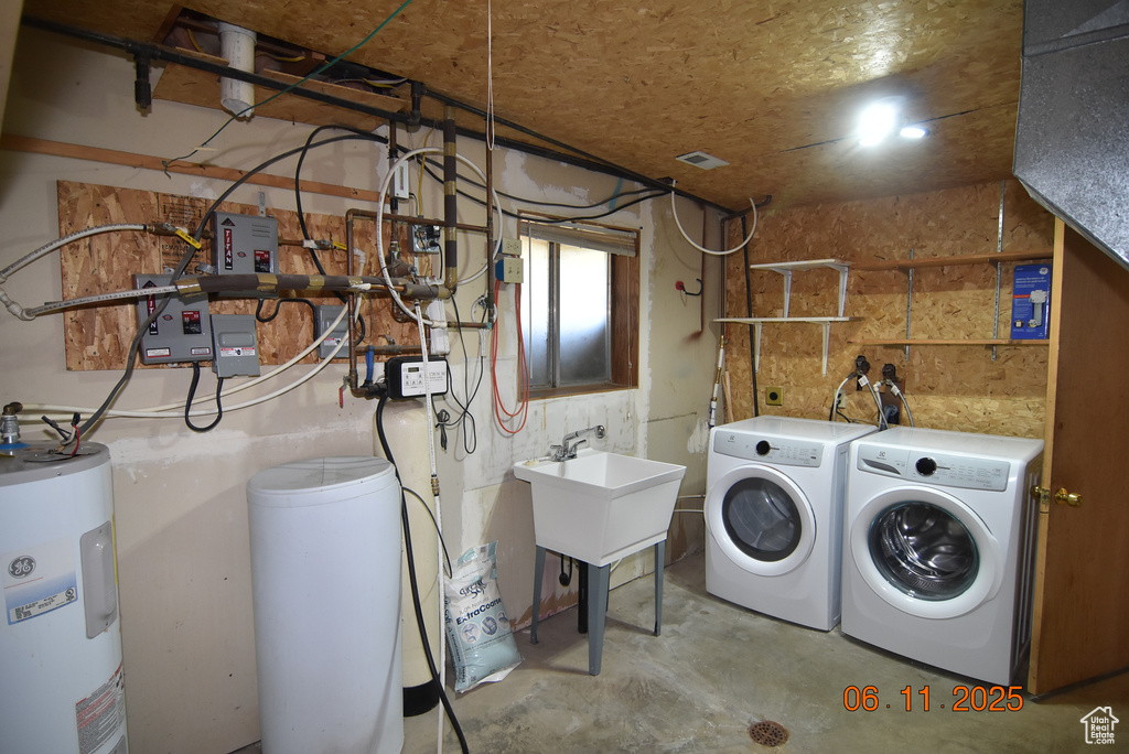 Laundry area featuring electric water heater and washing machine and clothes dryer
