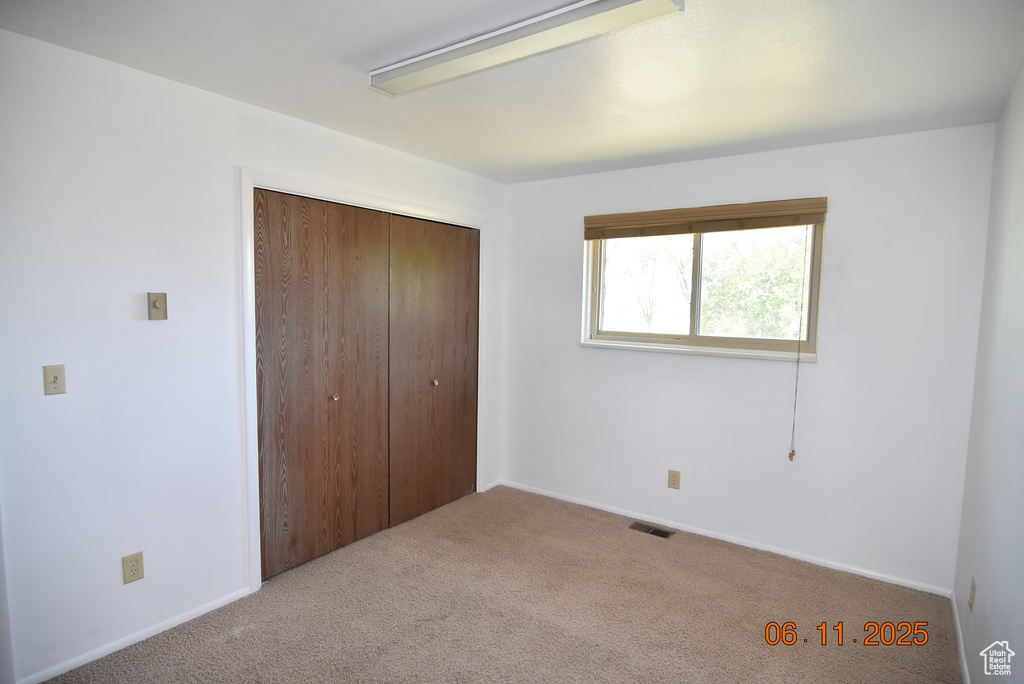 Unfurnished bedroom featuring carpet and a closet