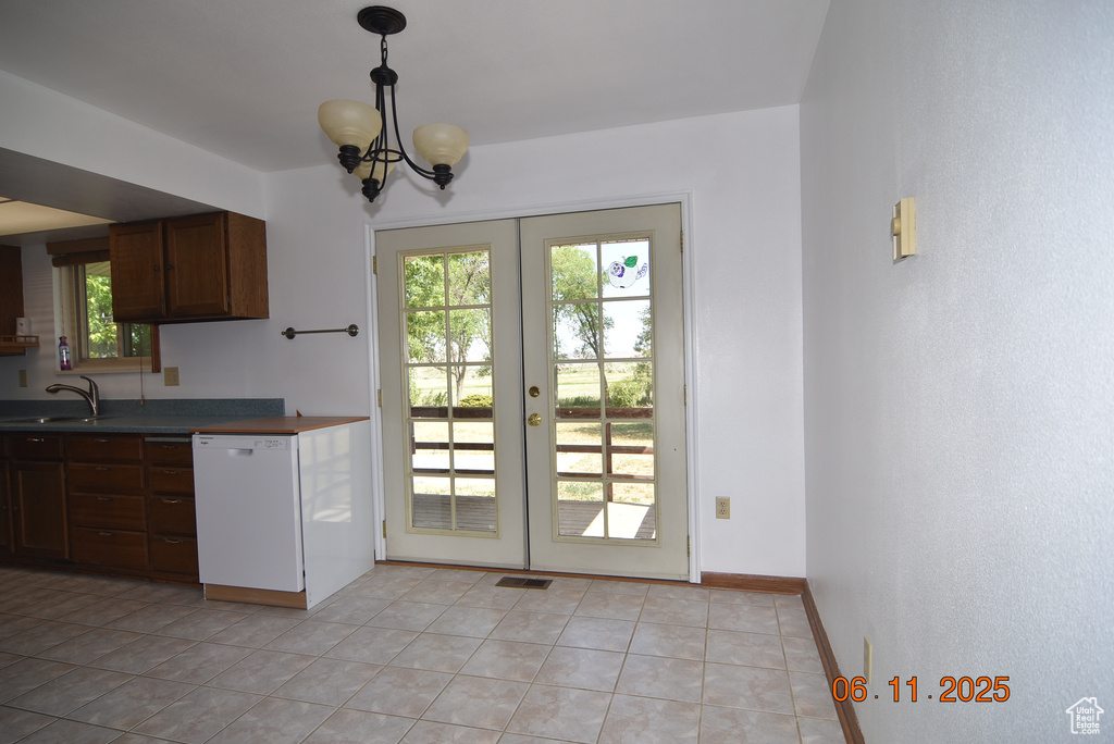 Kitchen with dishwasher, french doors, dark countertops, and light tile patterned flooring
